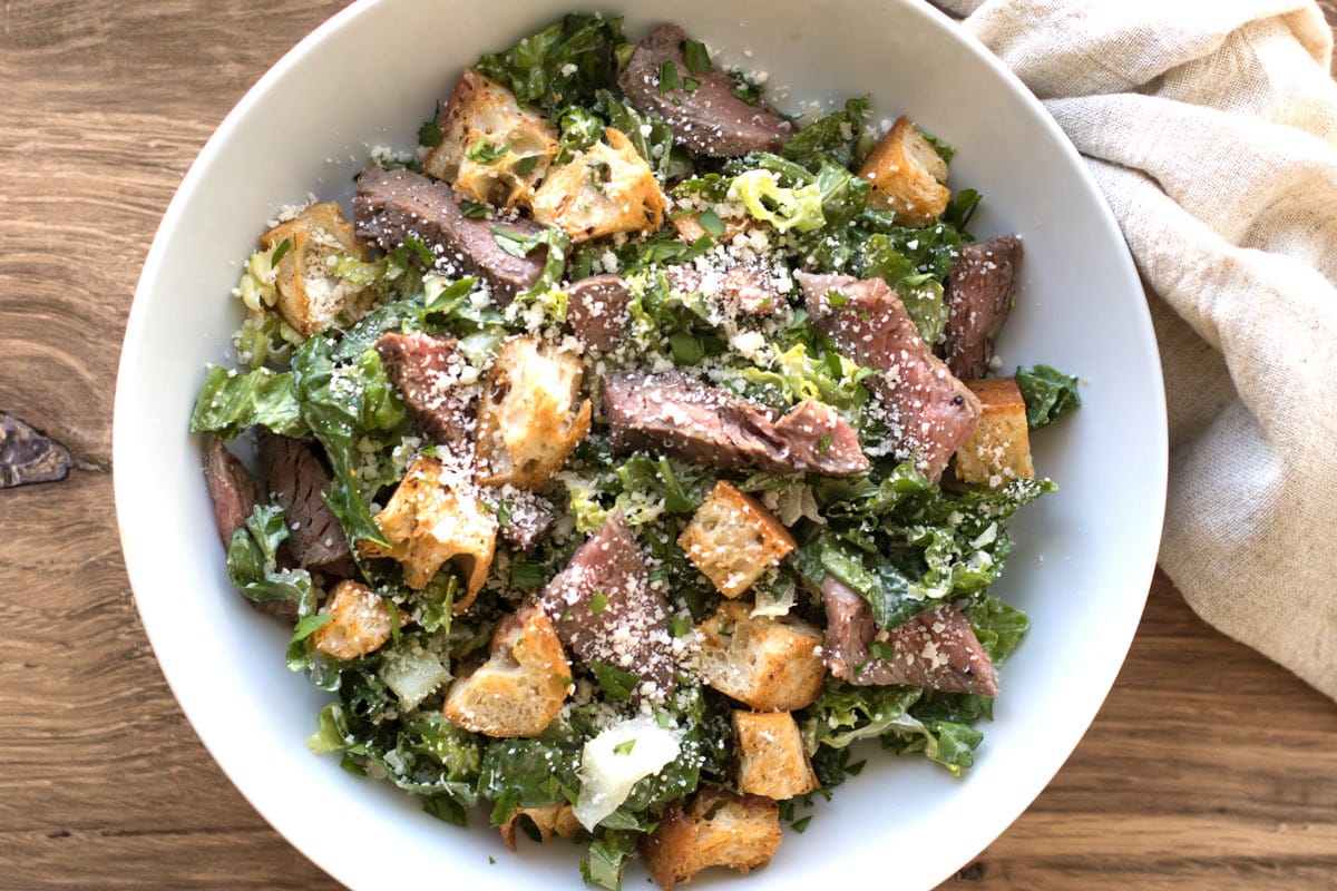 salad with steak and croutons in a bowl.