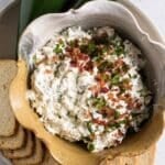 jalapeno popper dip in a bowl with crackers.