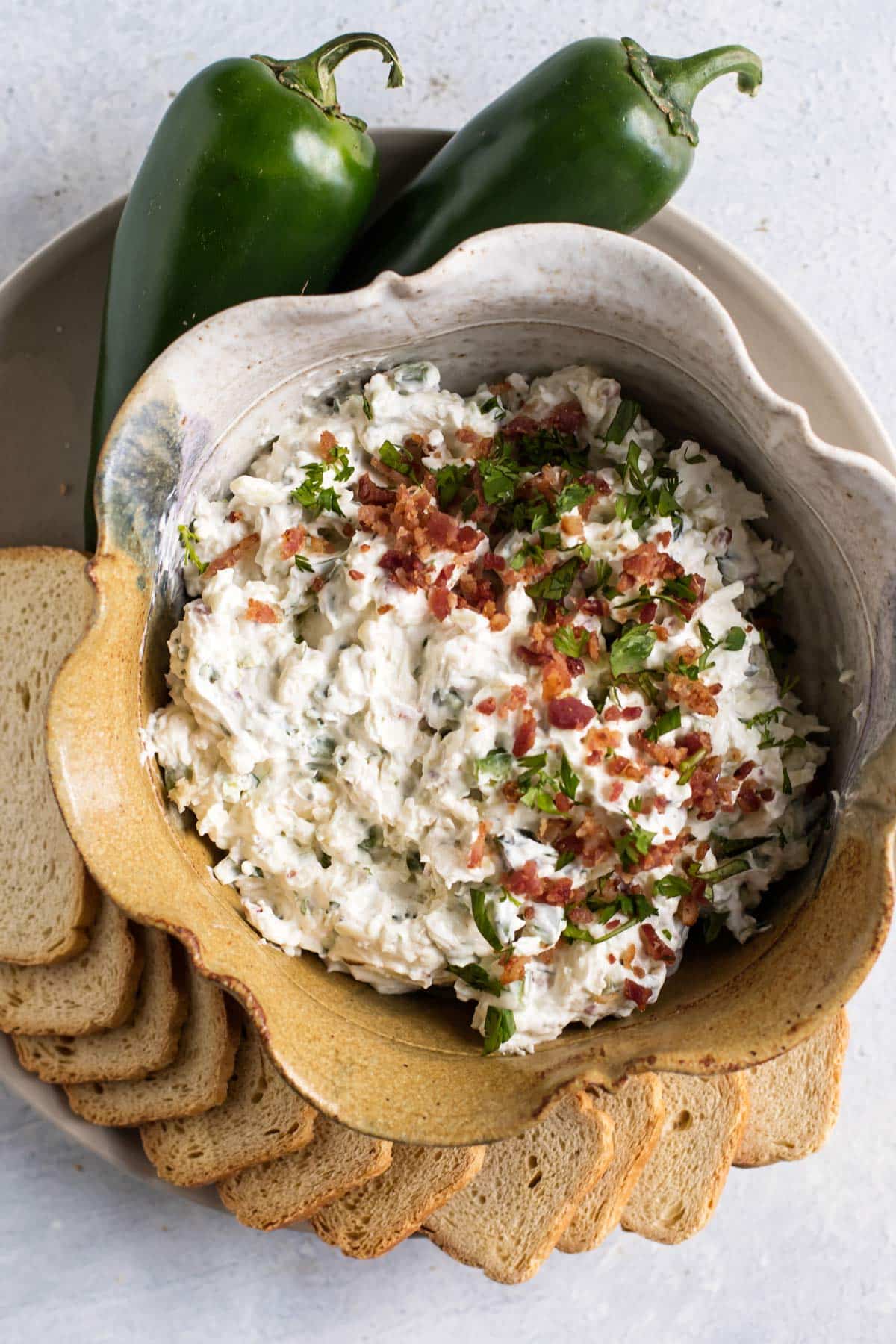 jalapeno popper dip in a bowl with crackers.