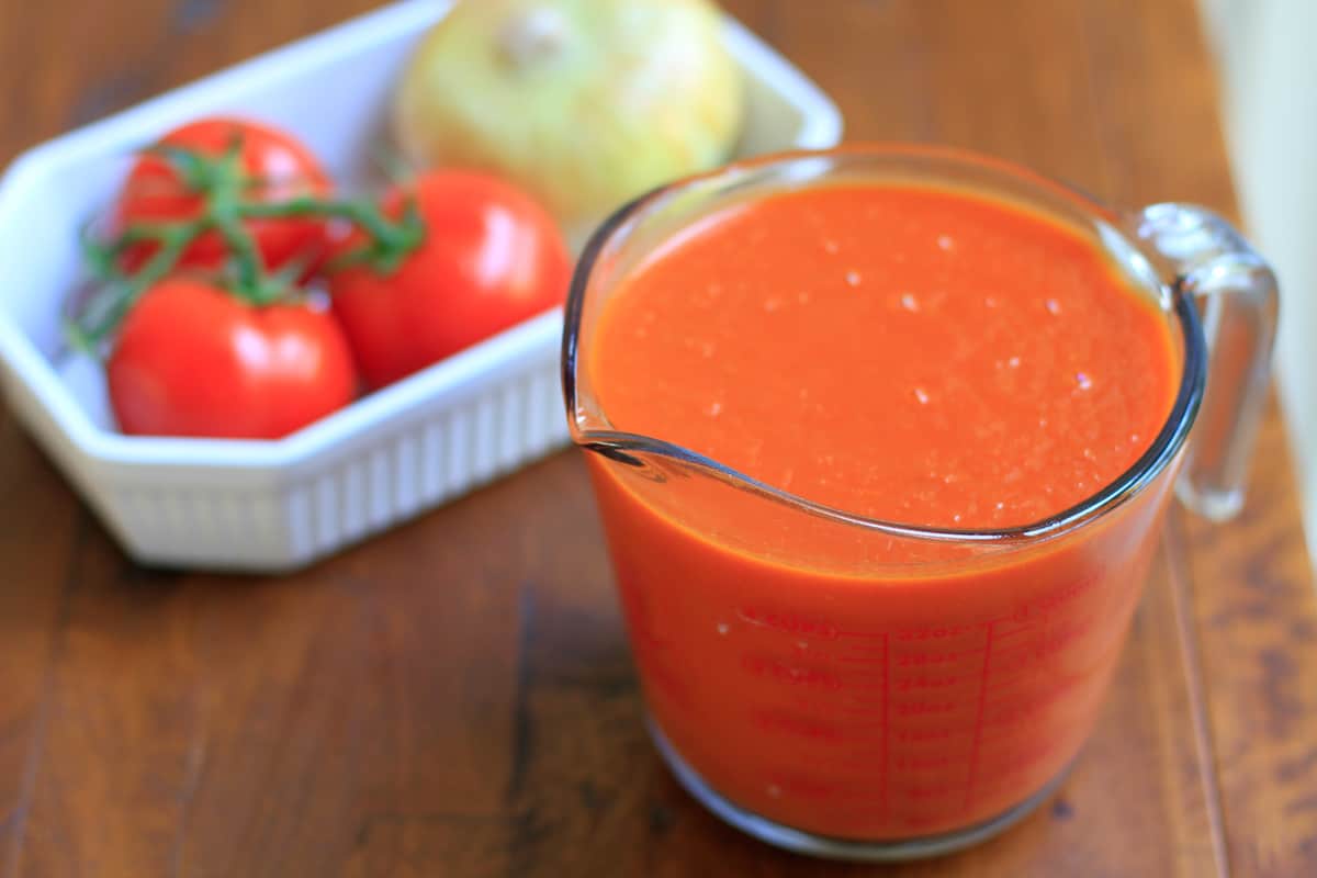a measuring cup filled with tomato puree.