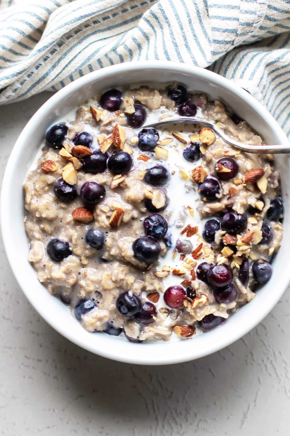a bowl of blueberry oatmeal with a spoon.