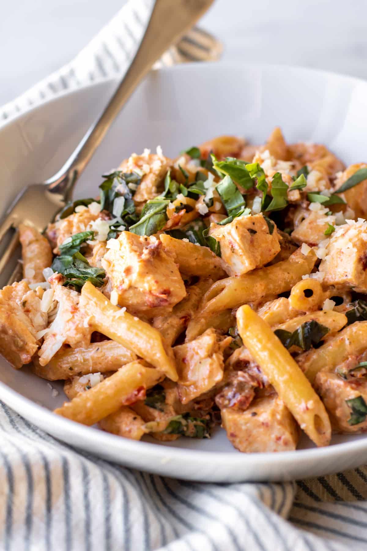 a bowl of creamy tuscan chicken penne.