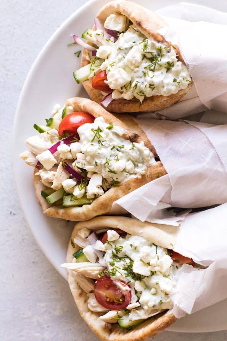 three chicken gyros on a plate.