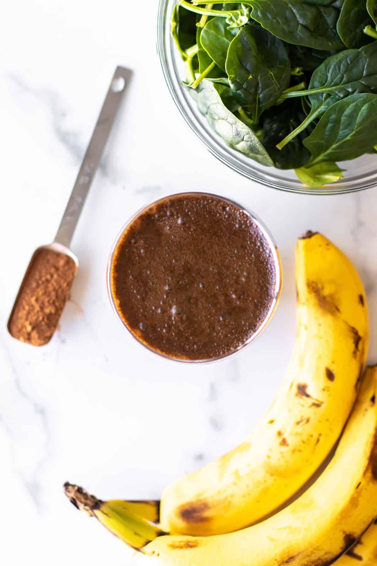 green coffee chocolate smoothie, bananas, spinach, and cocoa powder.