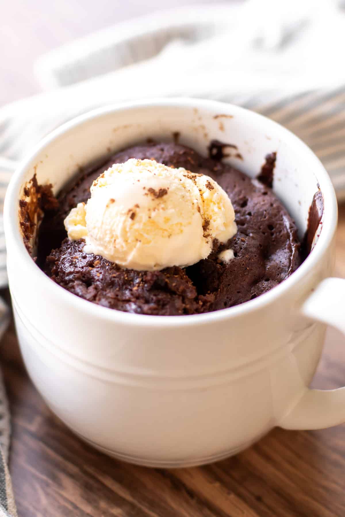 a chocolate mug cake with a scoop of vanilla ice cream.