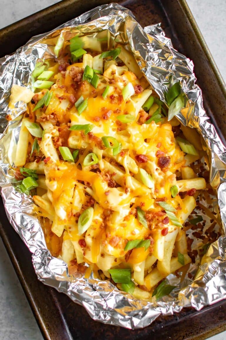 loaded cheese fries in foil on sheet pan.