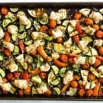 a pan of chicken with zucchini, tomatoes, and eggplant.