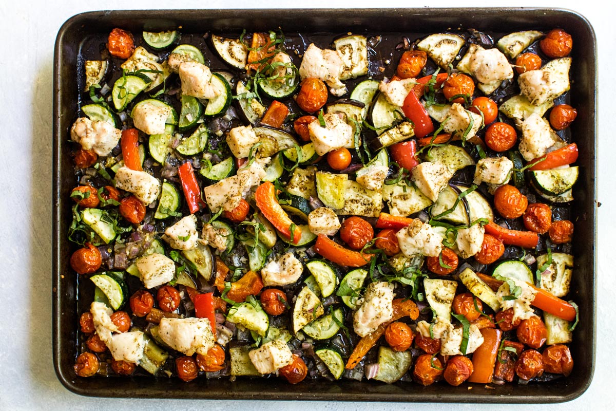a pan of chicken with zucchini, tomatoes, and eggplant.