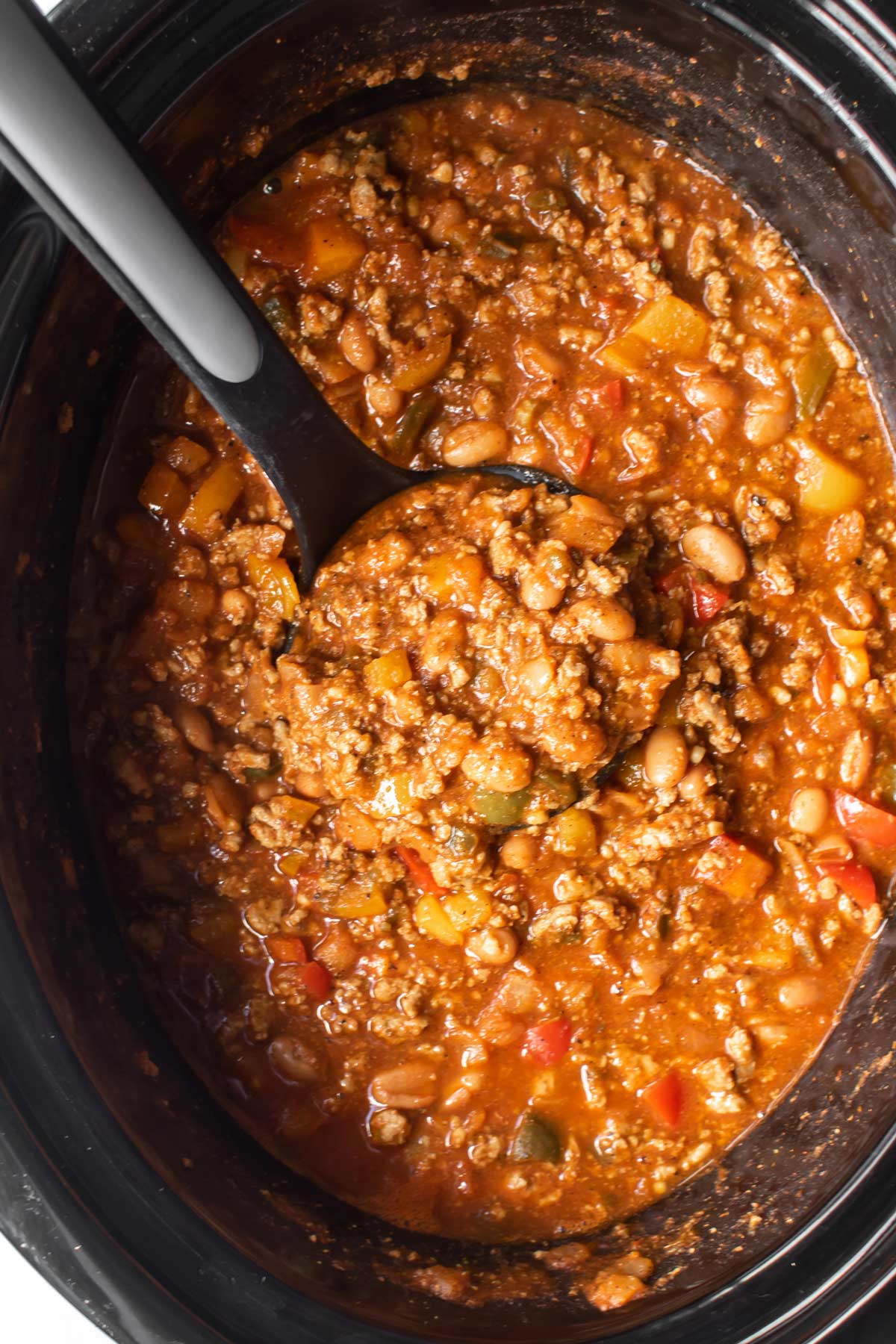 turkey chili in a slow cooker with a ladle.