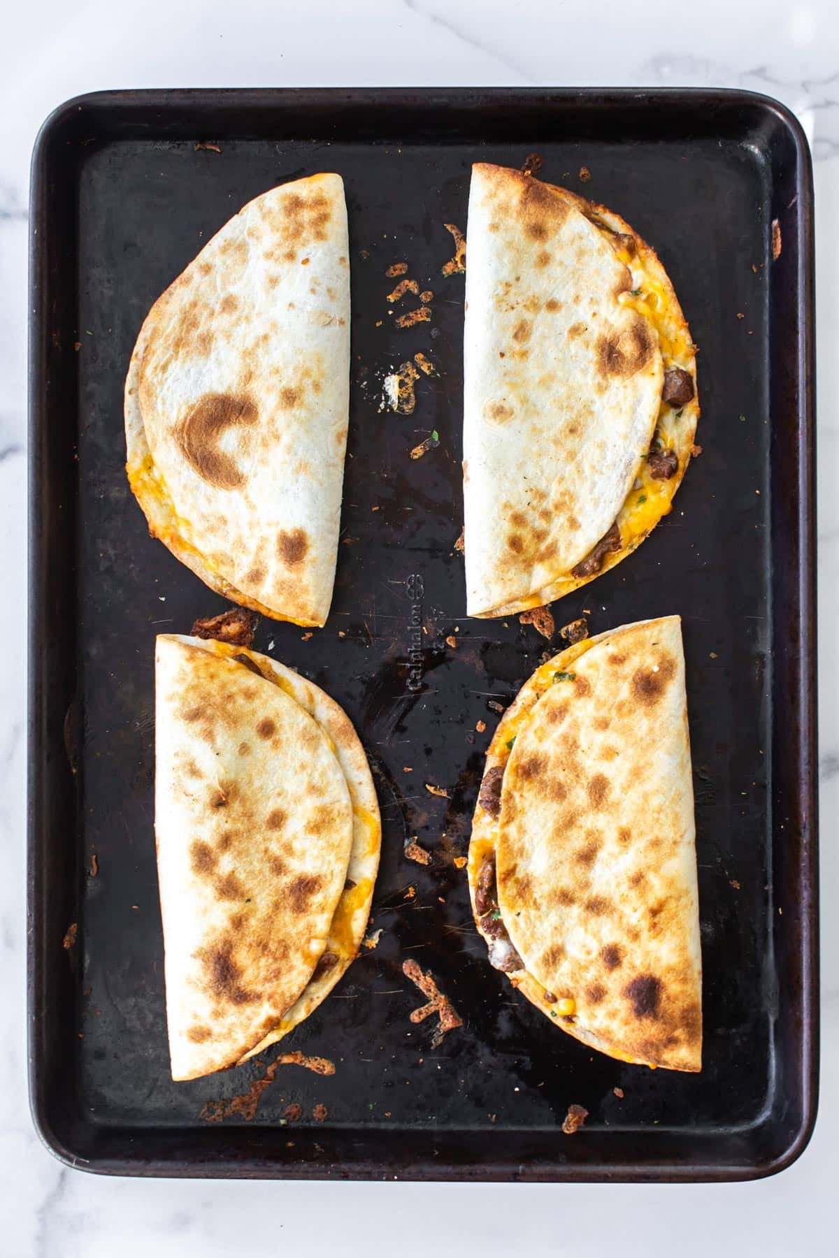 the cooked quesadillas on a sheet pan.