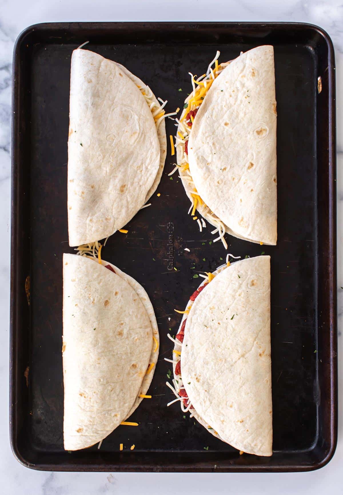 quesadillas on a sheet pan ready to be cooked.