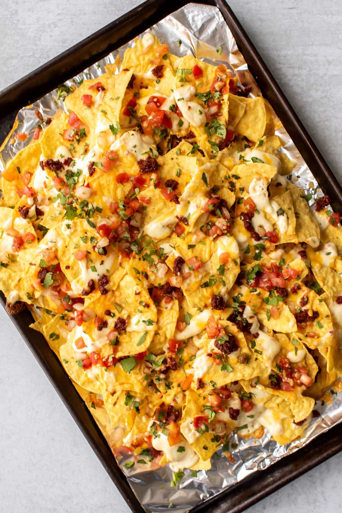 baked chorizo nachos on a pan.