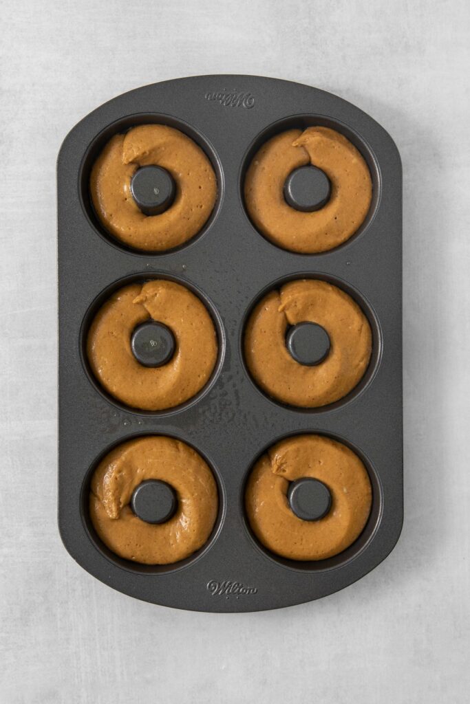 the batter in the donut pan.