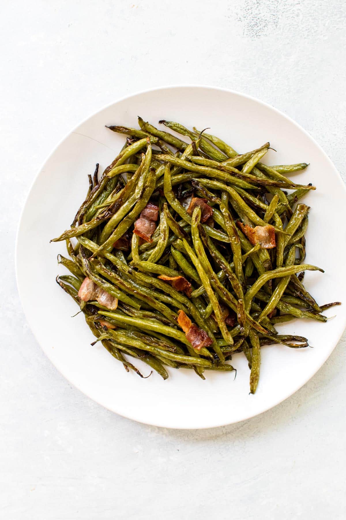 roasted green beans and bacon on a plate.