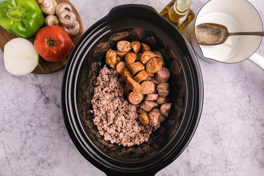 sausage and ground beef added to the slow cooker.