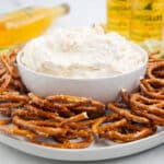 a bowl of beer dip with pretzels surrounding it.