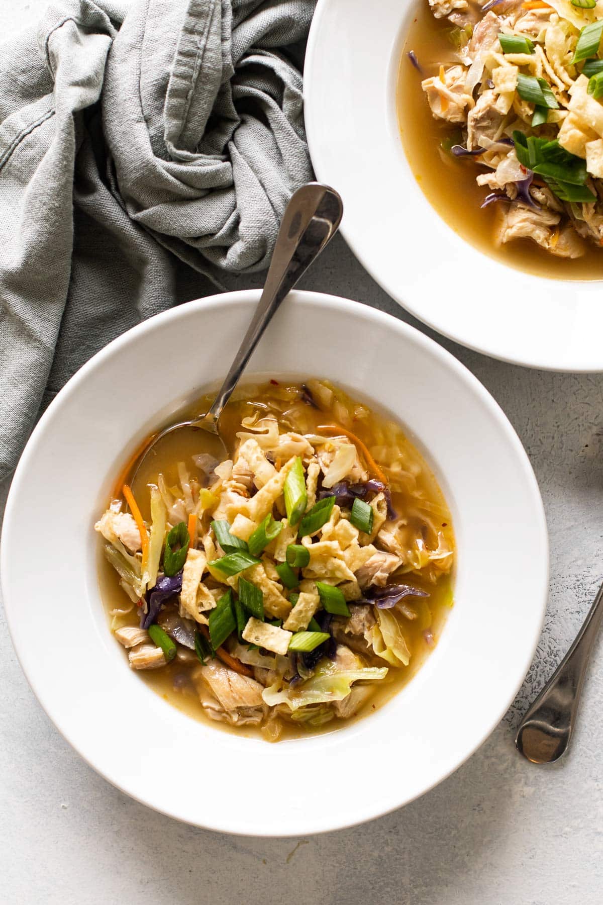 a bowl of egg roll soup with a spoon.