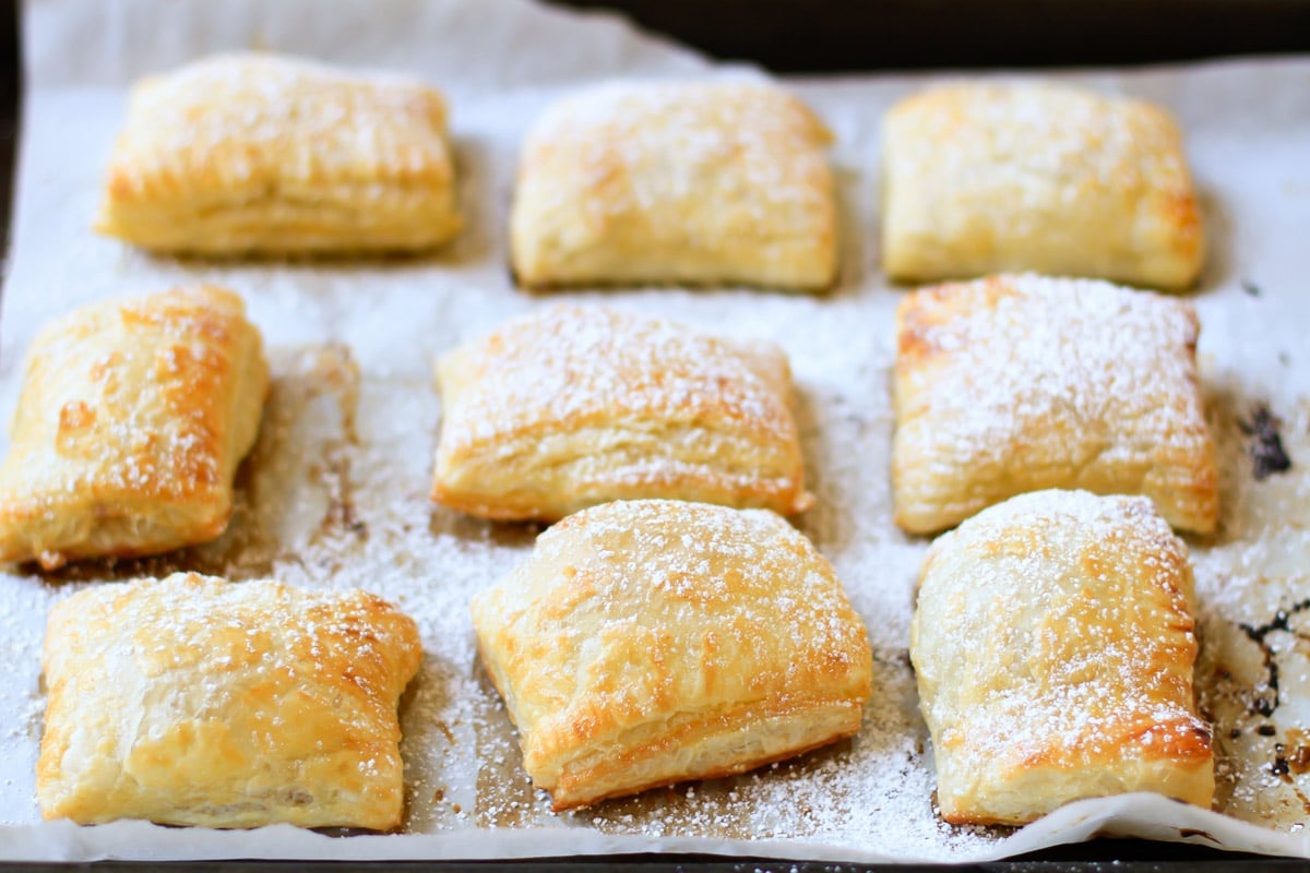 jam and cream cheese pastries on a baking sheet lined with parchment paper.