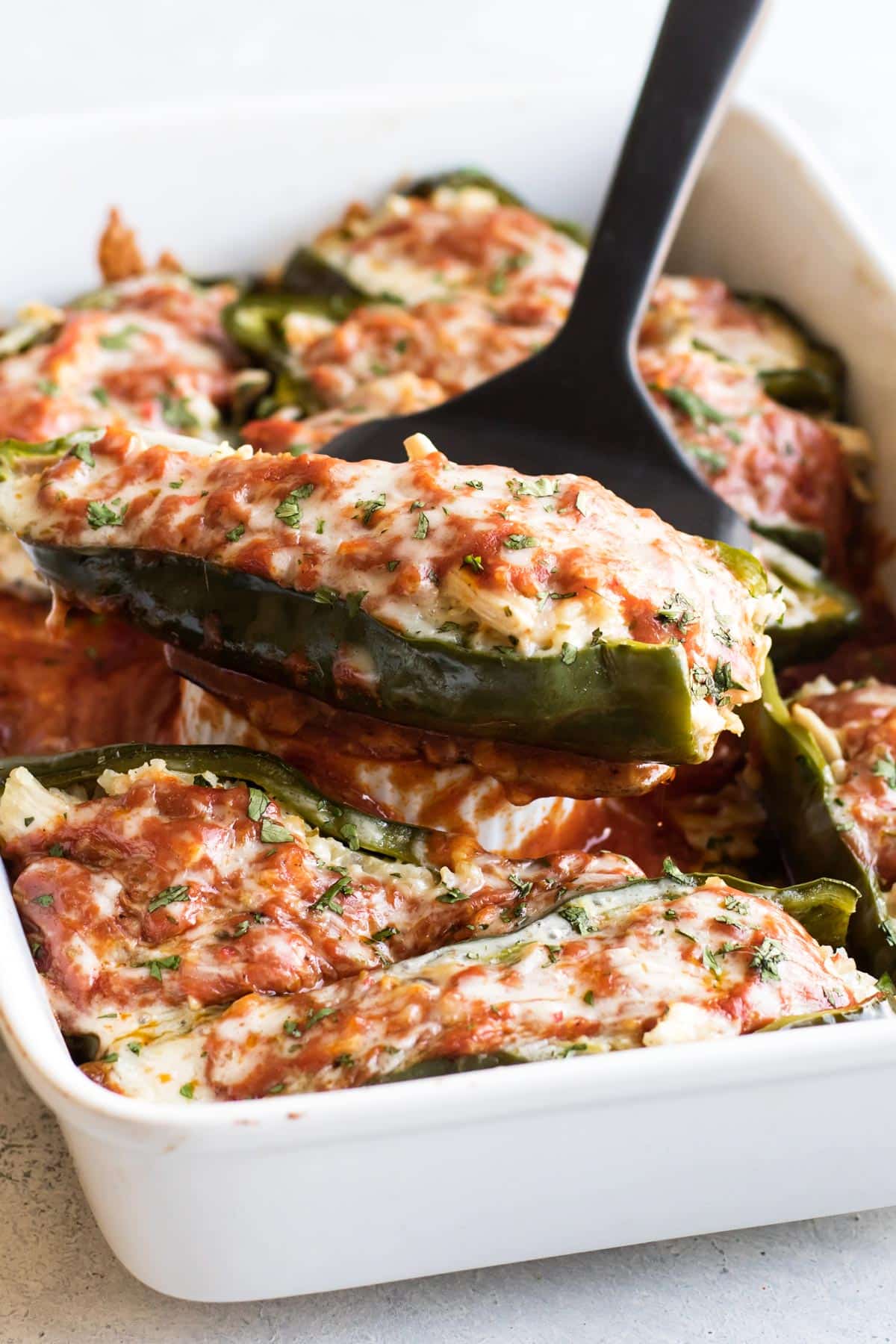 a stuffed pepper being lifted from the pan.