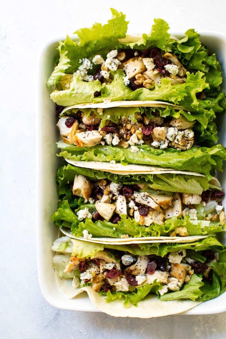 chicken wraps lined up in a pan.