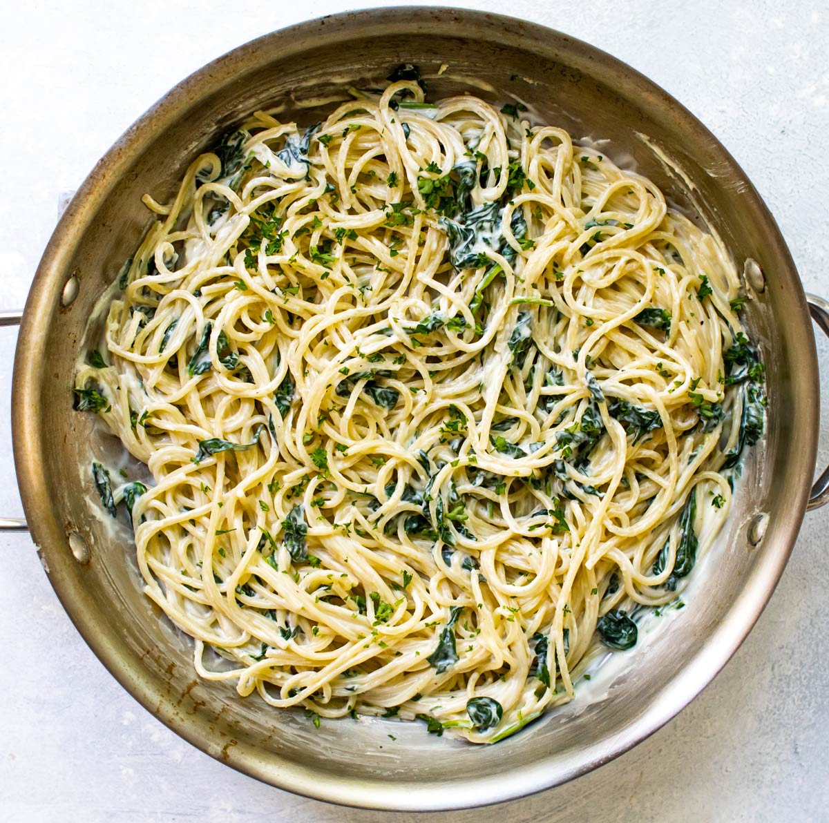 goat cheese and spinach spaghetti in a pan.