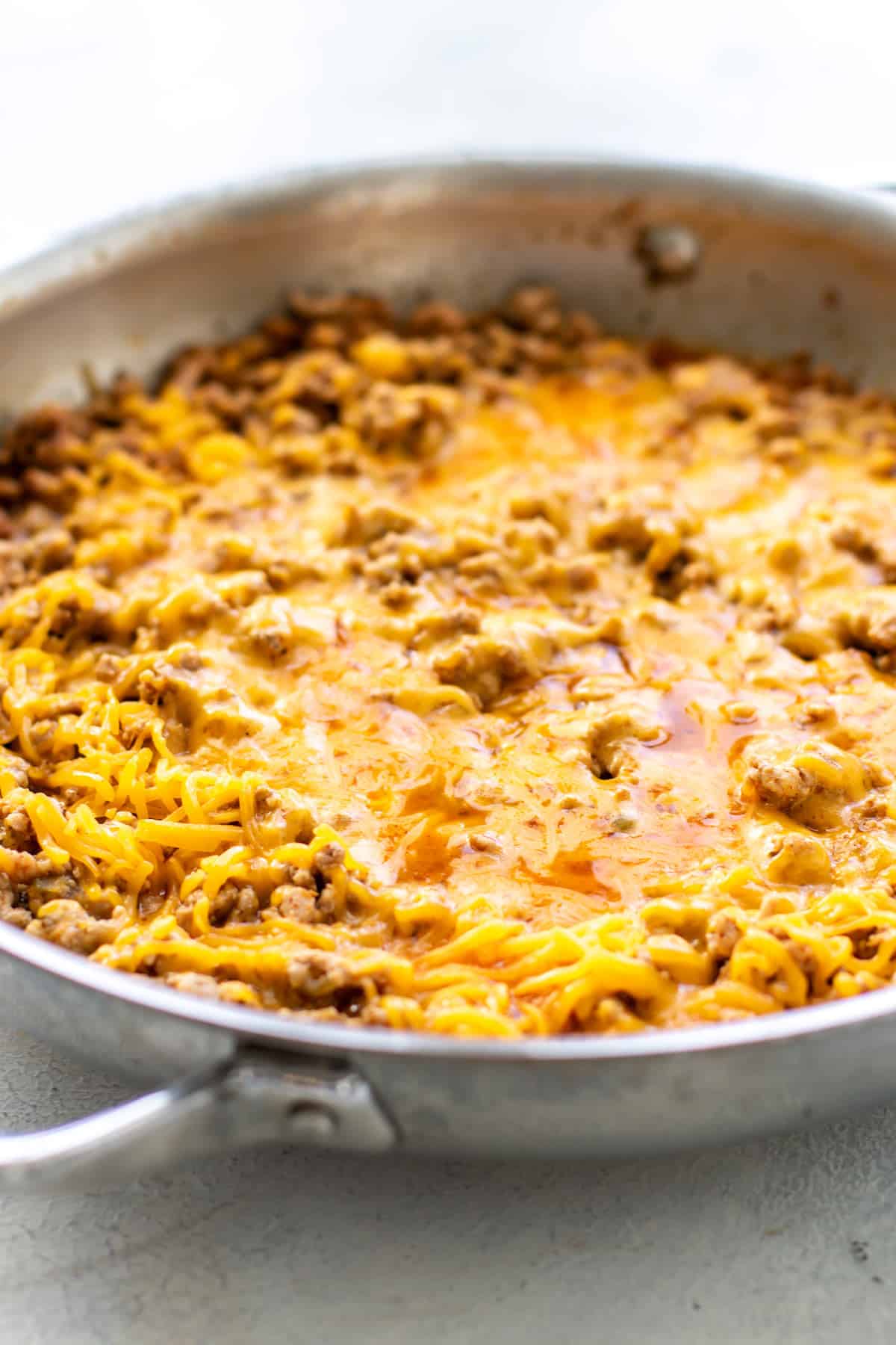 the pork verde in a pan topped with melted cheese.
