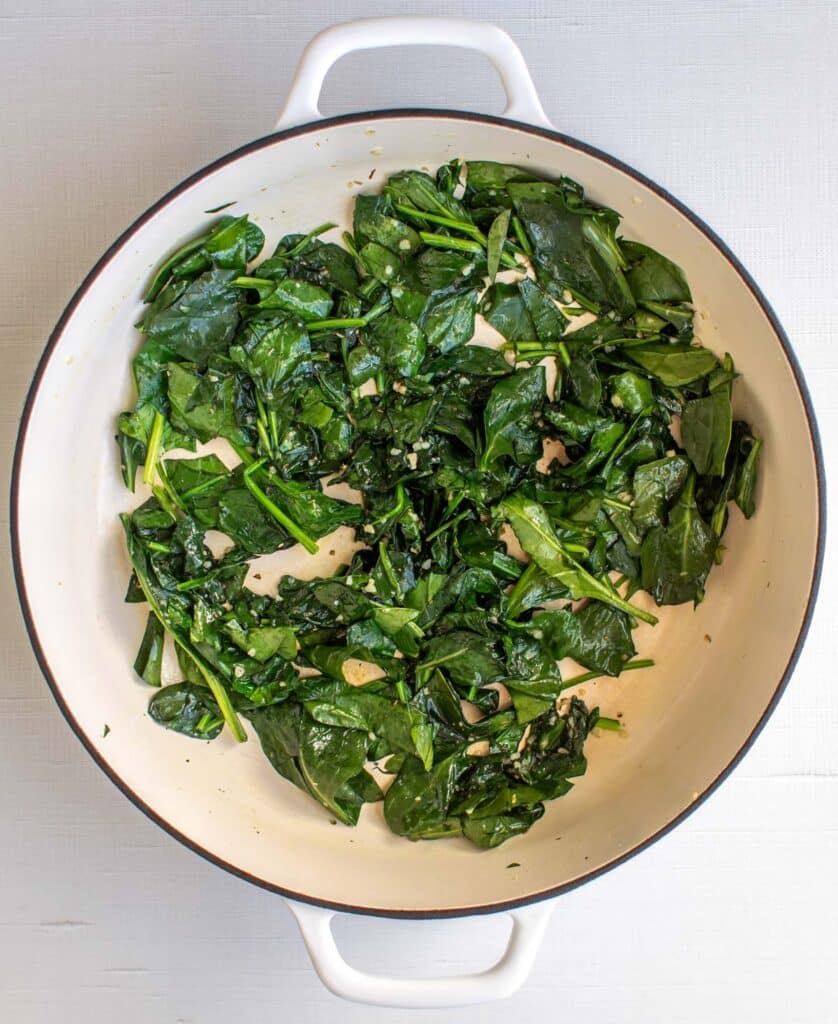 the wilted spinach in the pan.