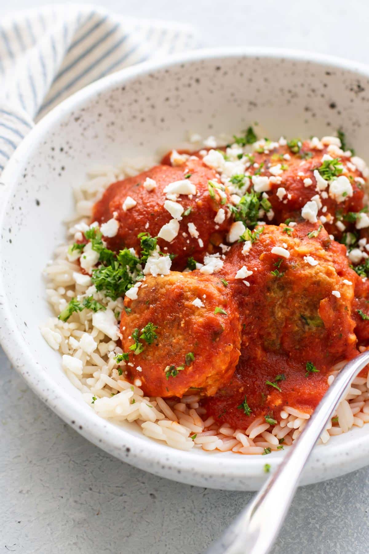 a bowl with rice and turkey meatballs with roasted red pepper tomato sauce.