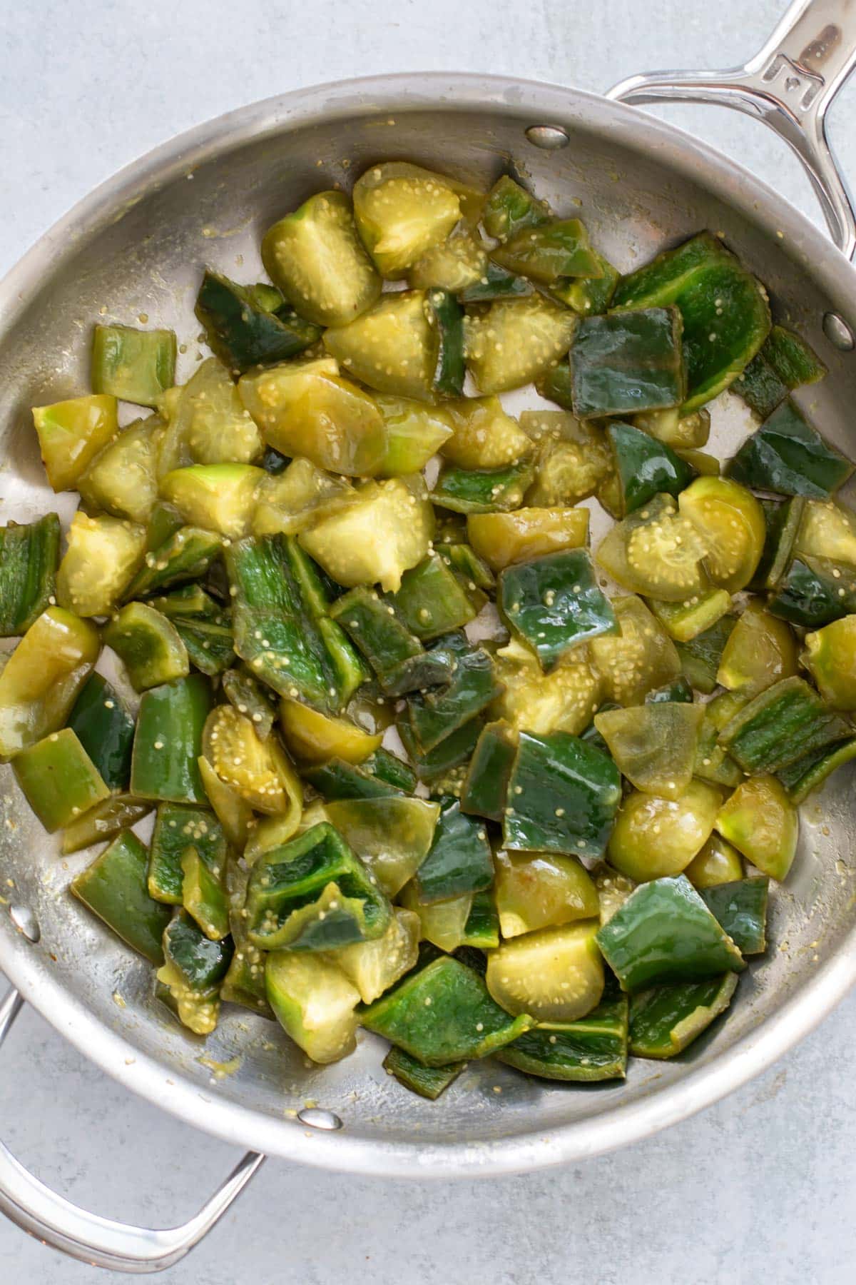 the cooked peppers and tomatillos in a pan.