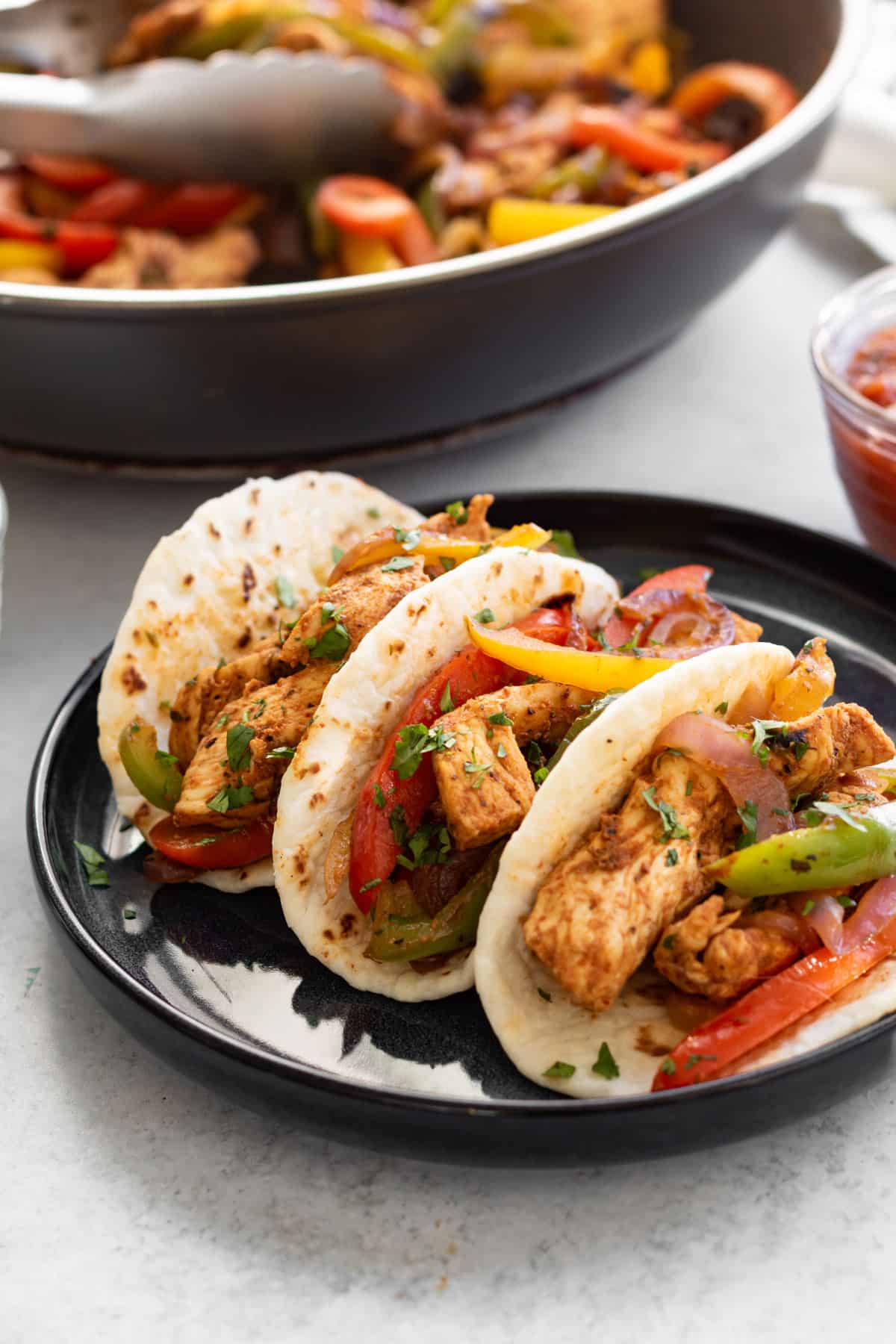 three adobo chicken fajitas on a plate.