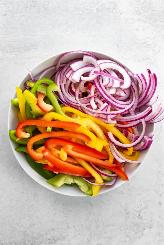 a bowl of sliced peppers and onions.