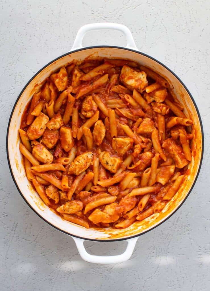 the cooked chicken, pasta, and sauce in the pan.