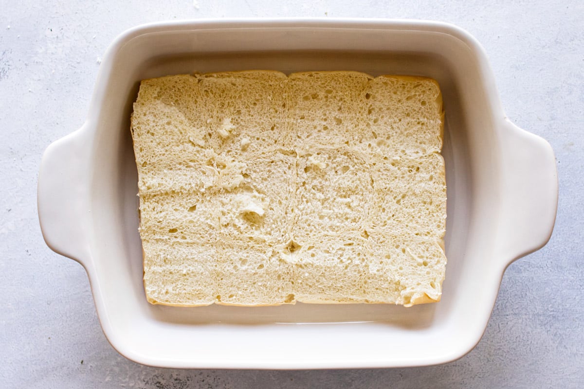 the bottom piece of the rolls in a baking dish.