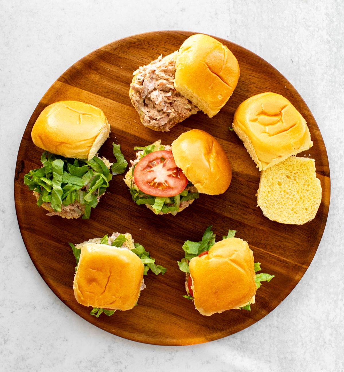 sandwiches being assembled on a cutting board.