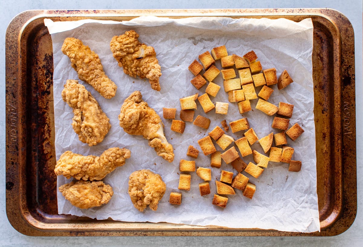 the croutons and crispy chicken on a sheet pan.