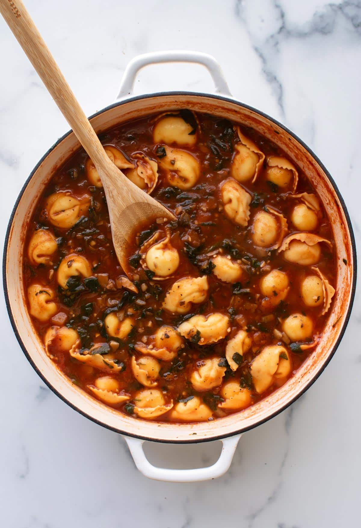 the cooked tortellini in the soup.