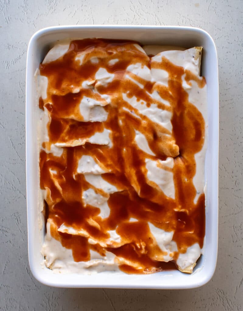 the enchiladas in the pan ready to be baked.