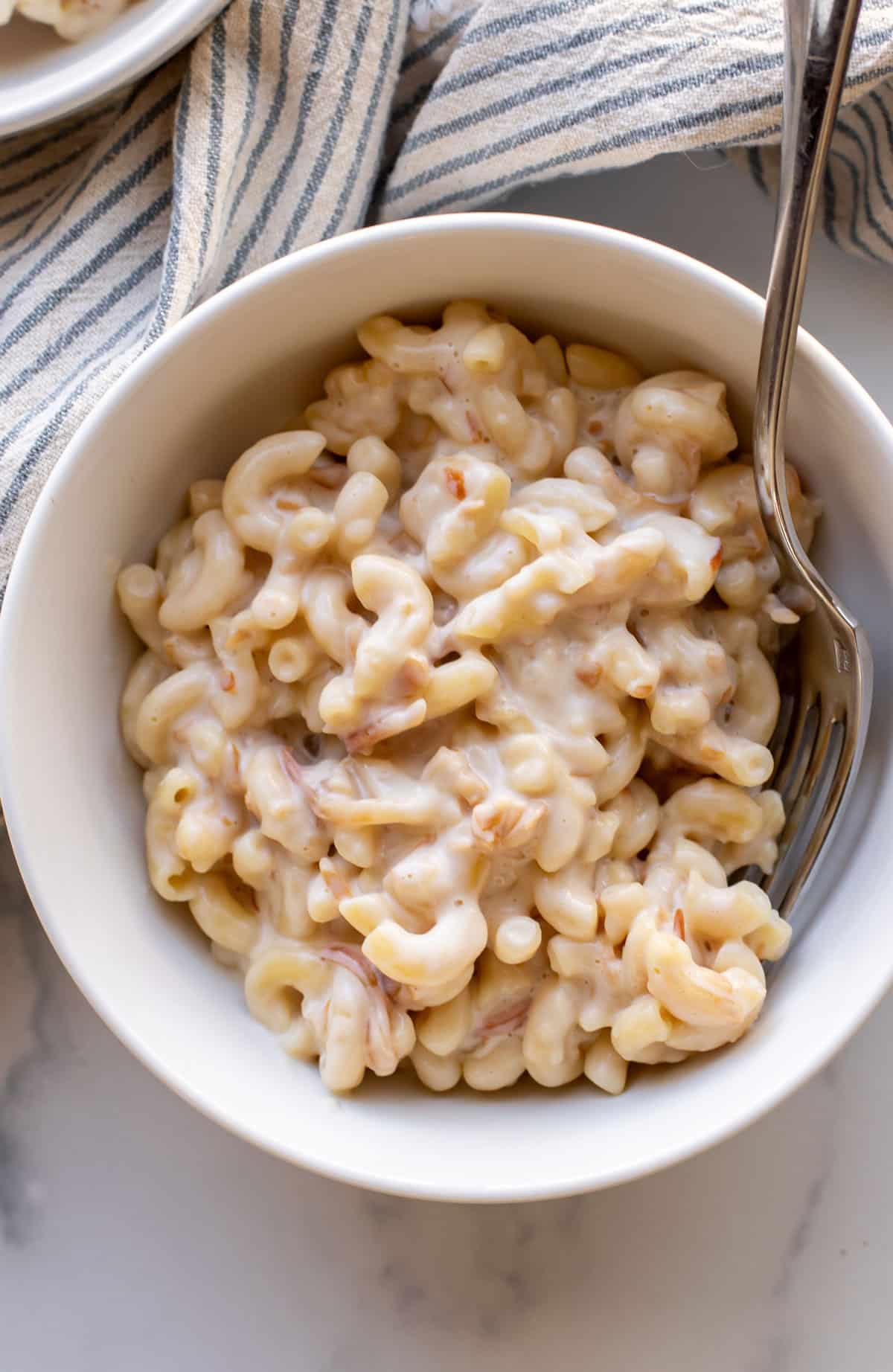 a bowl of smoked gruyere mac and cheese with a fork.