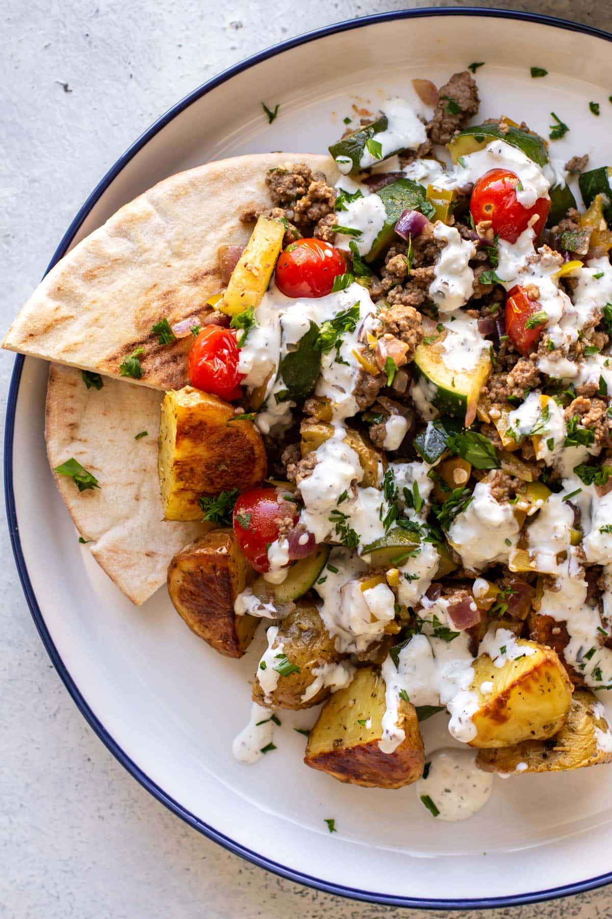 ground beef skillet, roasted potatoes, and pita on a plate.