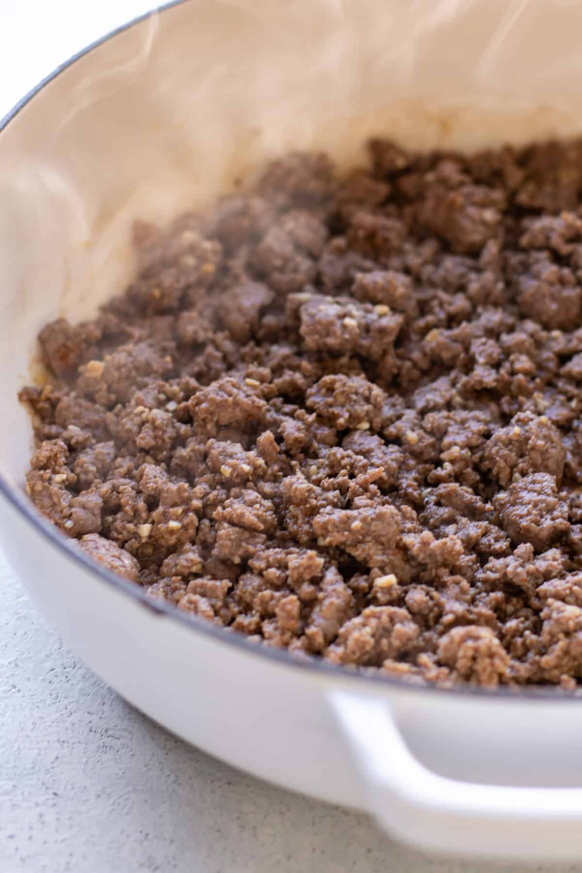 the seasoned beef in a pan.