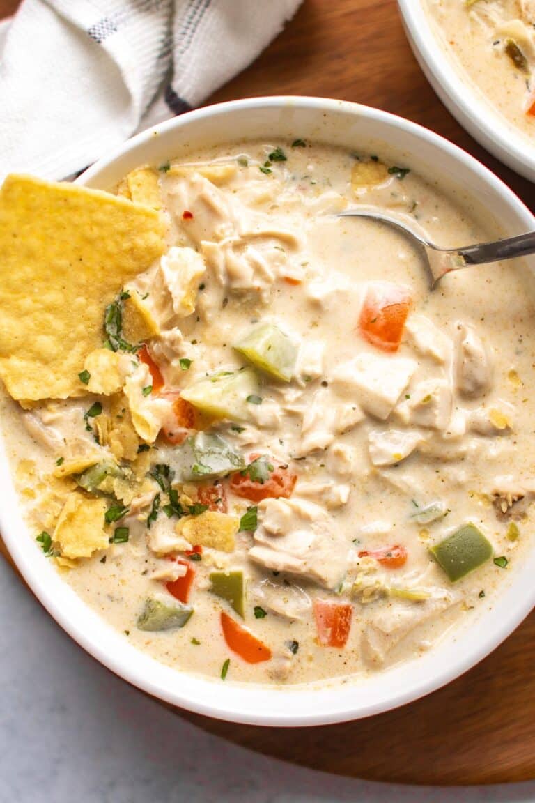 a bowl of chicken chili with tortilla chips and a spoon.