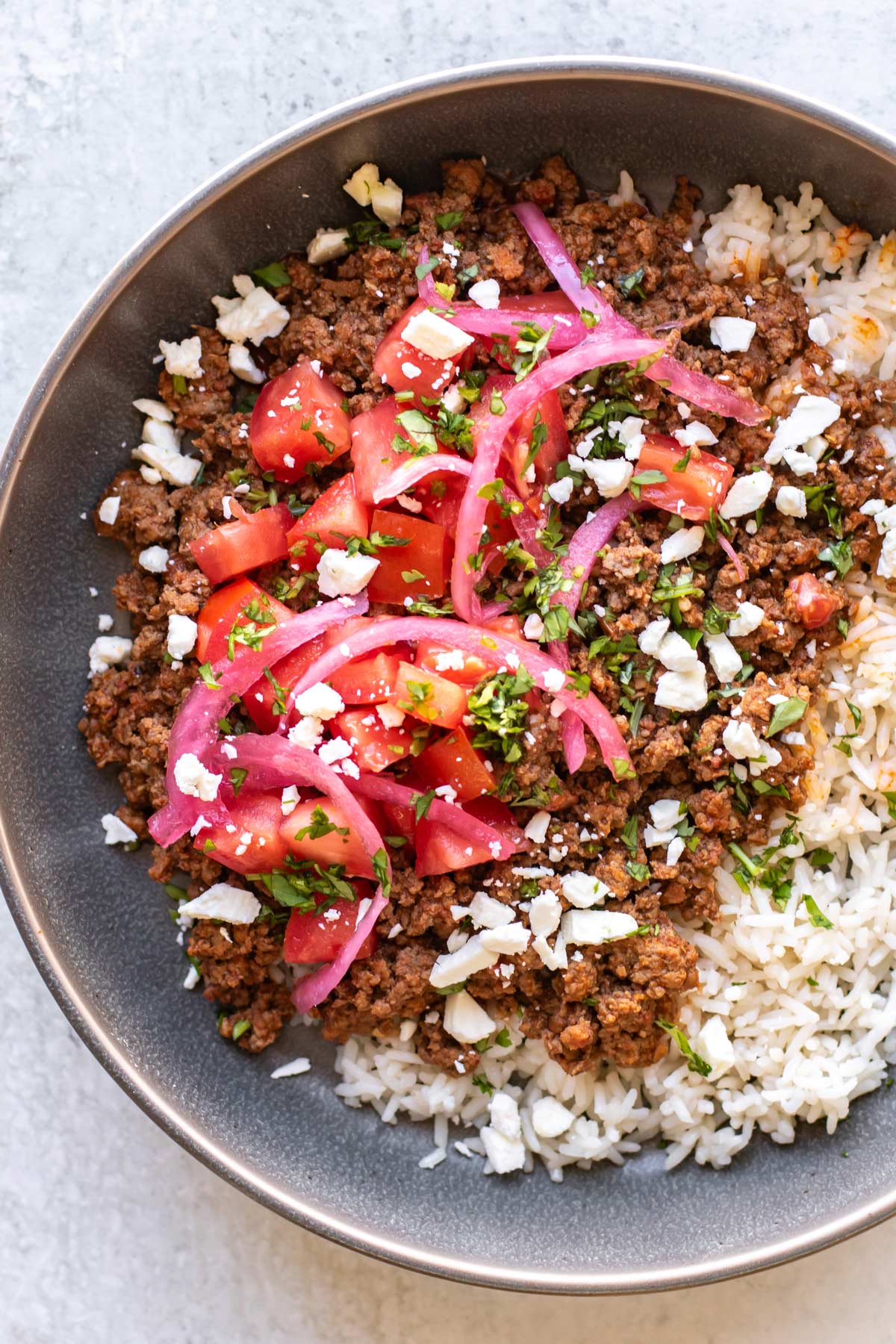 chorizo beef bowls with rice, tomatoes, feta, and pickled onions.