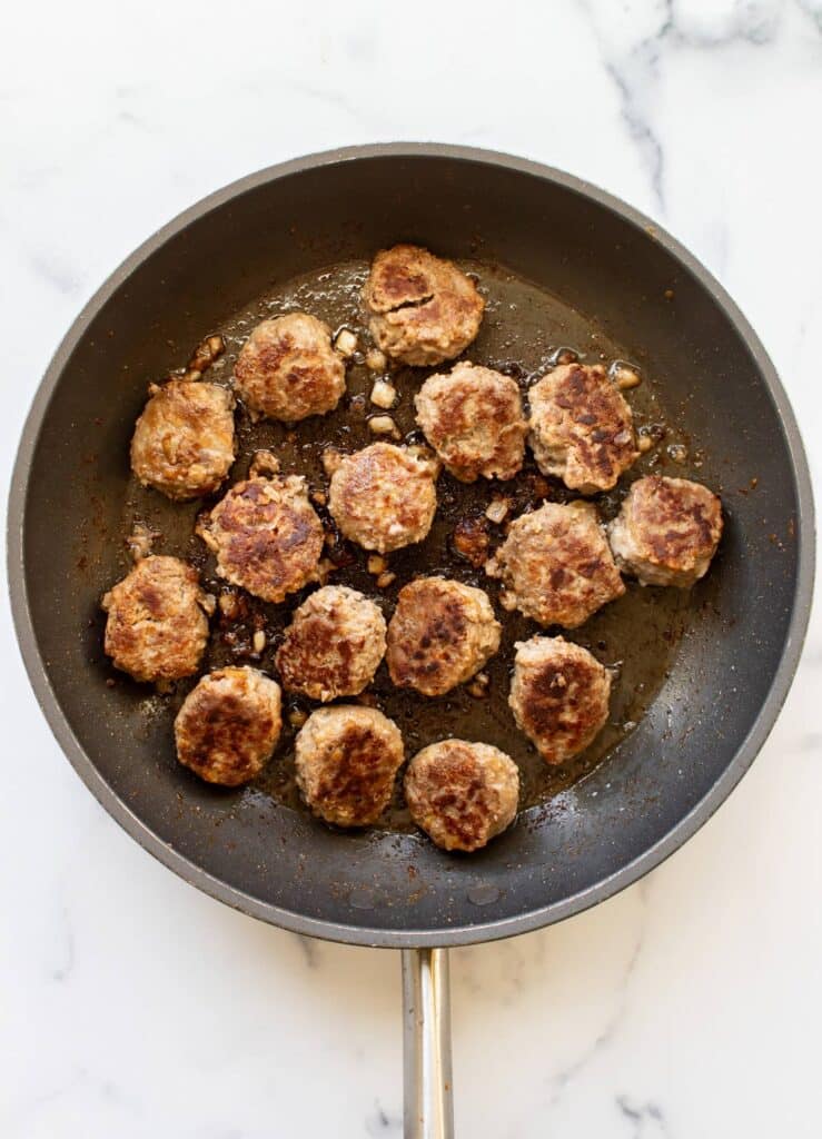 the browned meatballs in the pan.