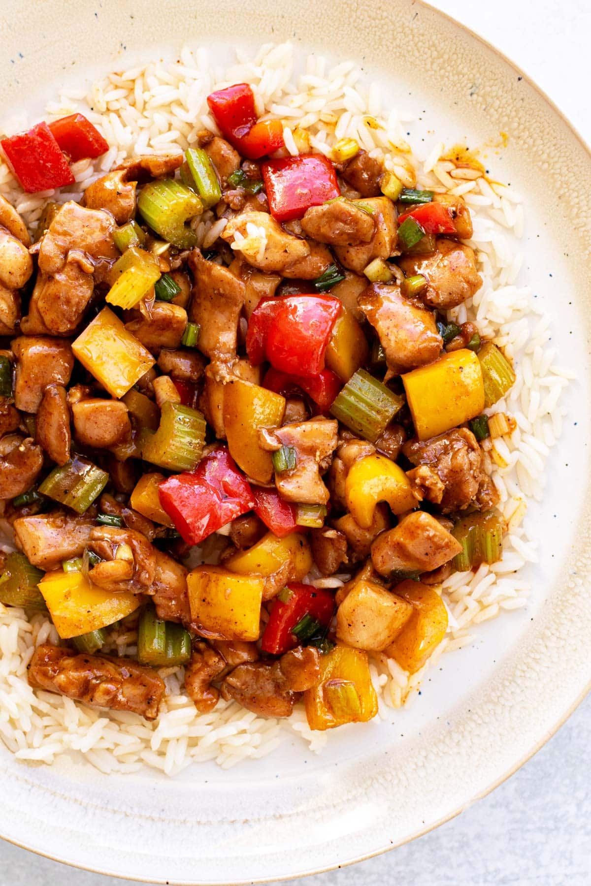 chicken stir fry on a plate with white rice.