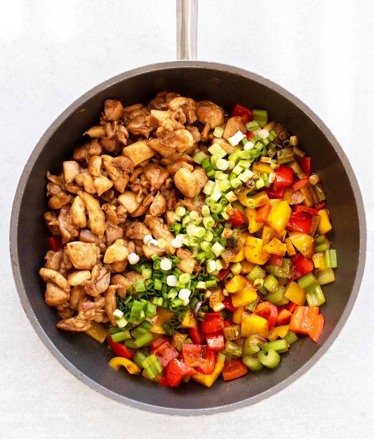 the chicken, sauce, and veggies in a pan.